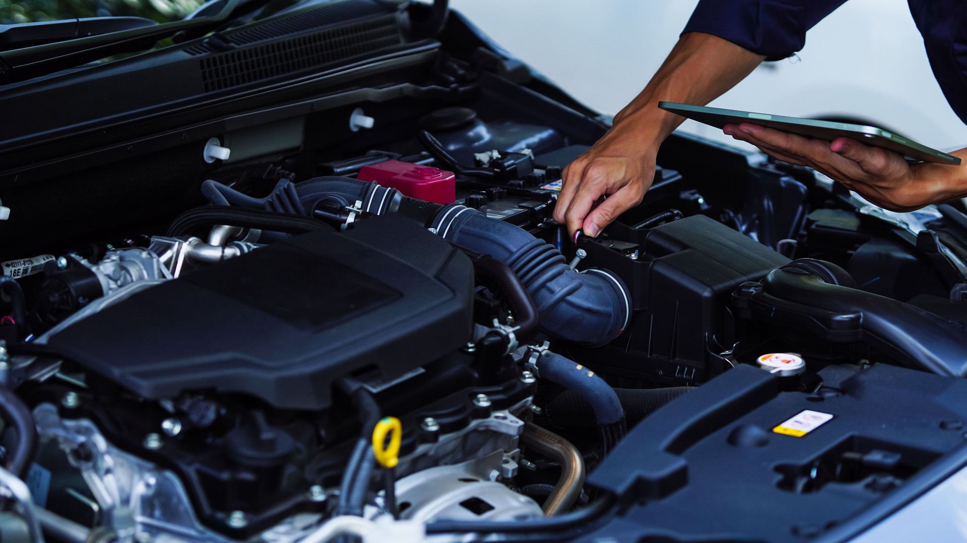 Auto mechanic hands using wrench to repair auto engine. Car maintenance, service at garage. Technician inspects vehicle for problems. Auto repair, fixing, check, services, insurance, checkup concept.