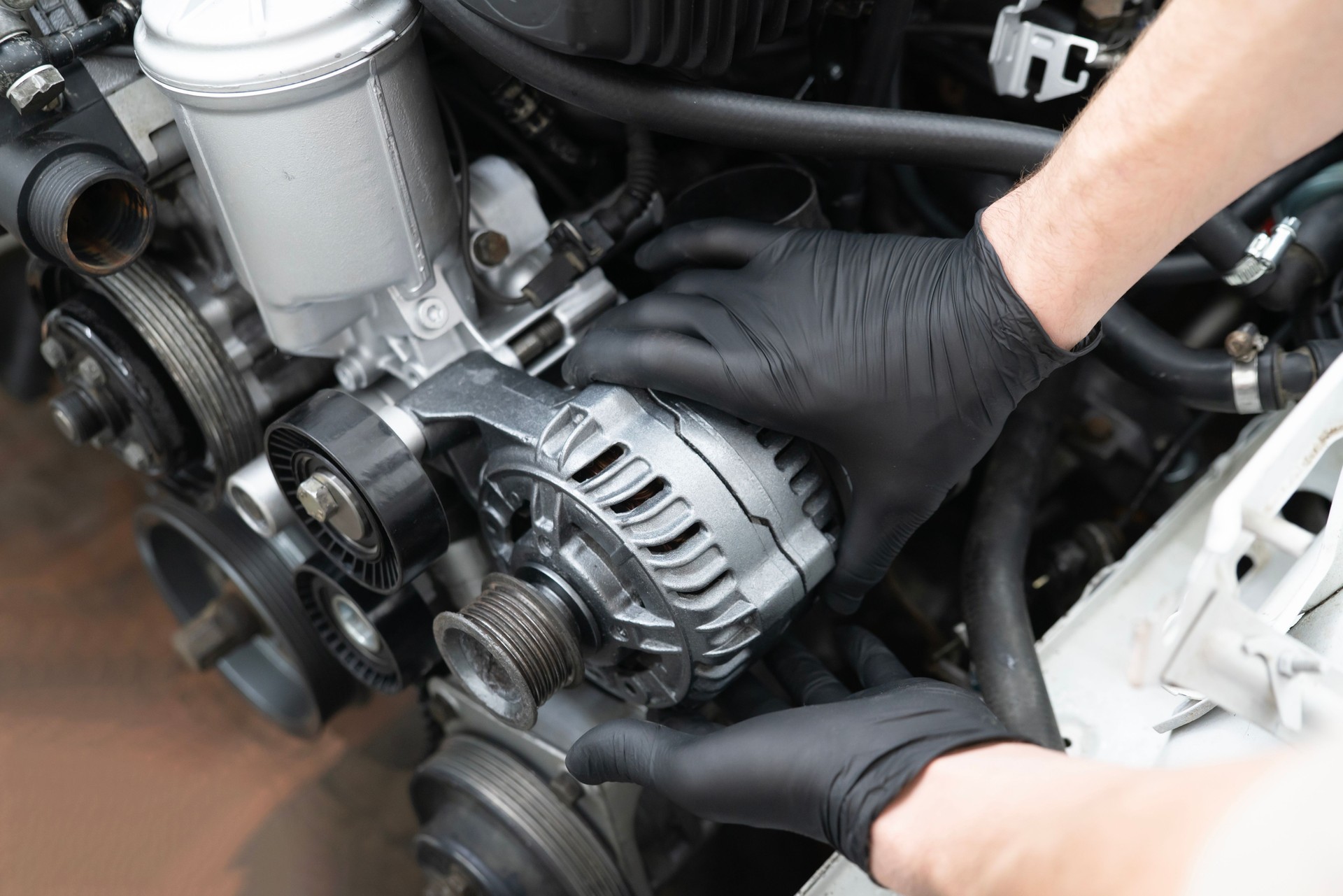 Car Mechanic Installs Generator in an Engine Compartment During Service at an Auto workshop